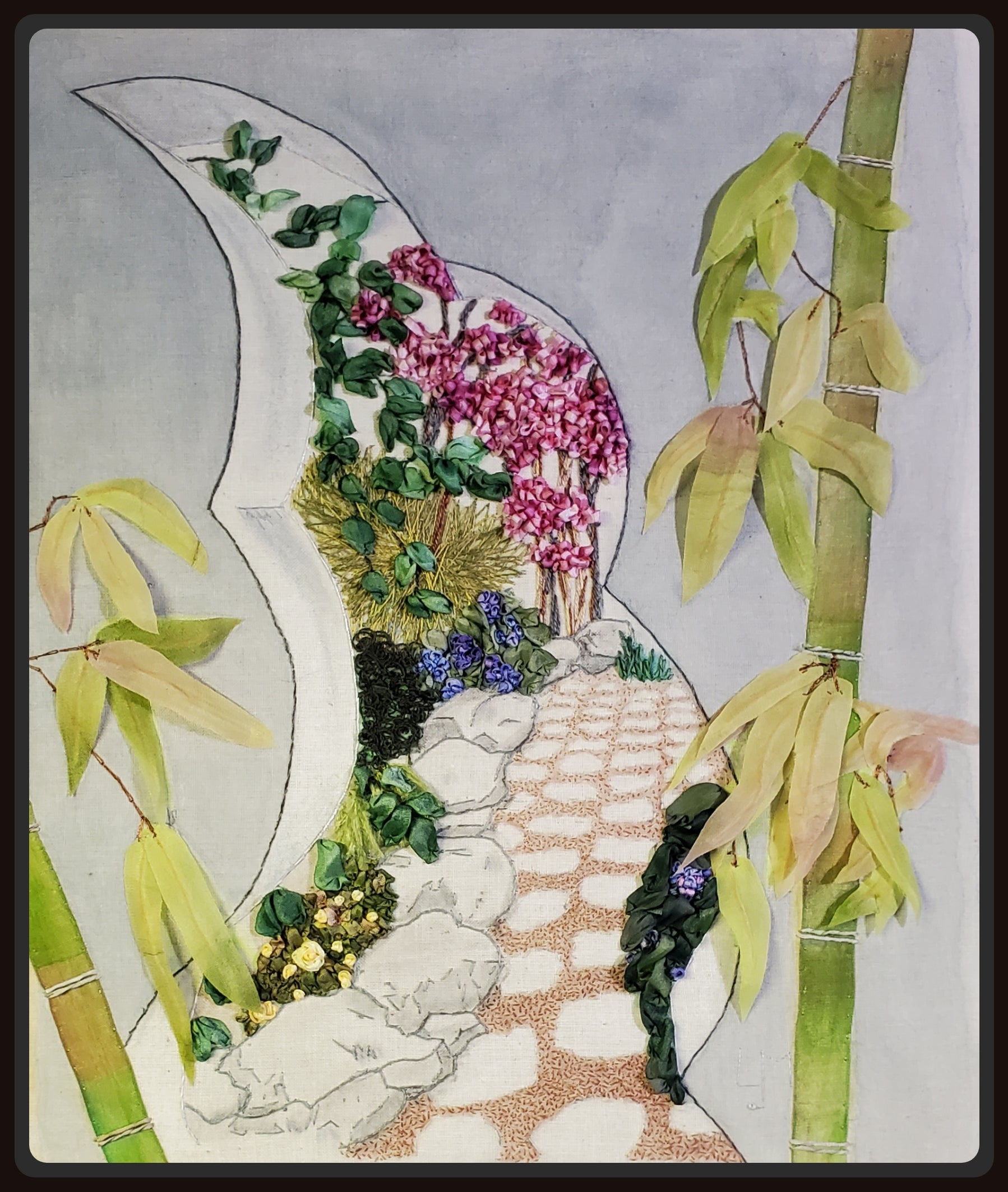 Decorative piece with floral arrangement and bamboo elements on a textured background