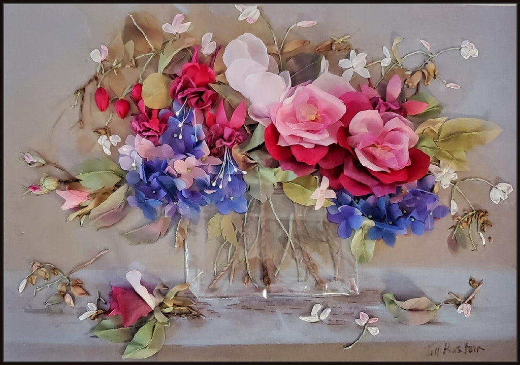 Colorful floral arrangement in a clear vase on a light background